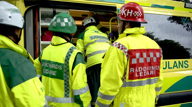 Räddningsledare och ambulanspersonal samlade vid ambulans.