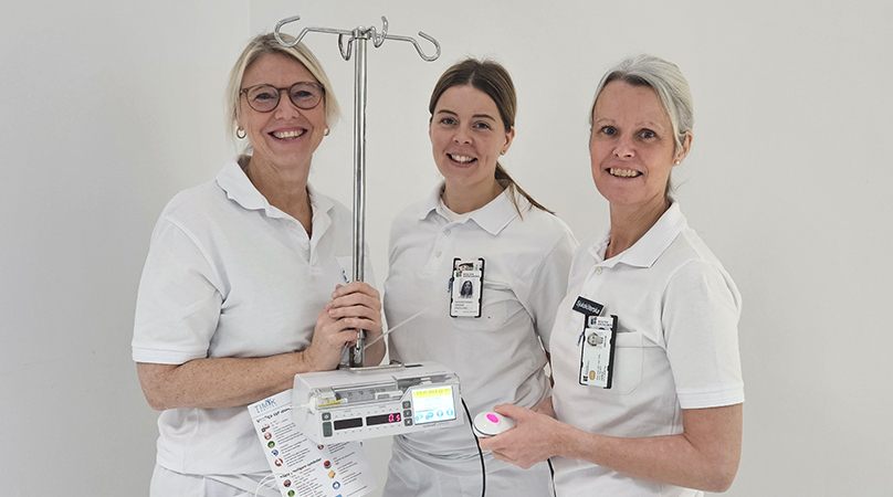 Tre anställda som jobbat med införandet på endoskopienheten står vid en läkemedelspump.