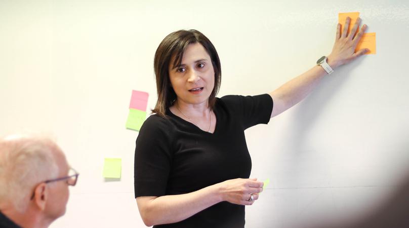 En kvinna presenterar för en grupp.