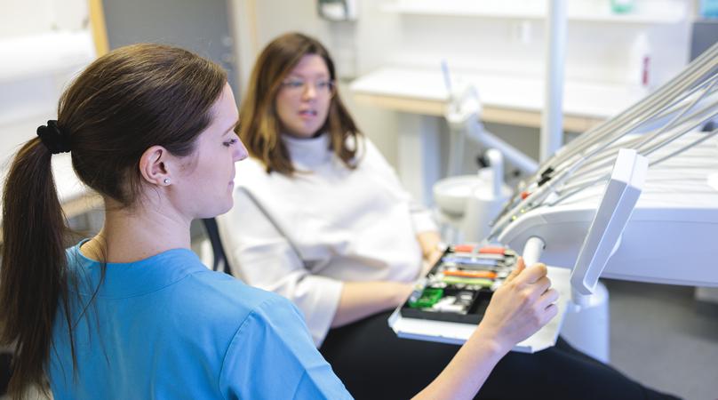 Kvinna sitter i behandlingsrum hos tandläkaren.