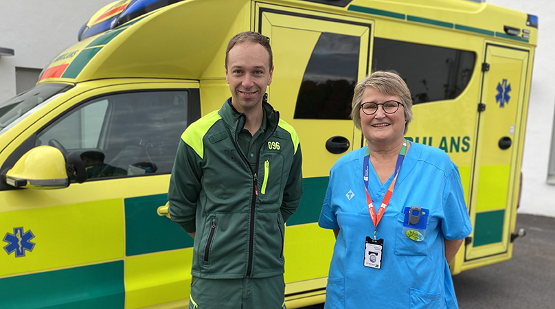En man och en kvinna står framför en ambulans.