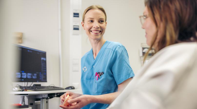 Tandsköterska och patient pratar