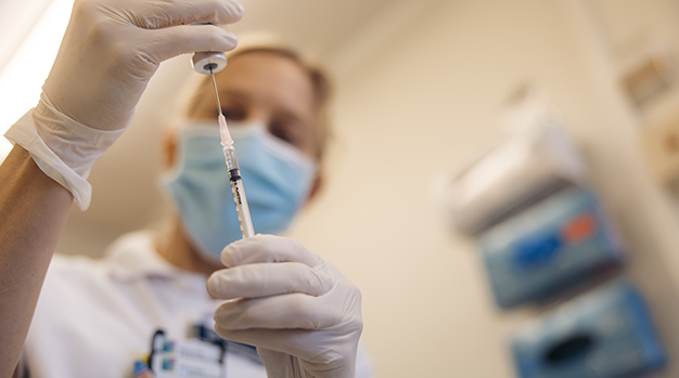 Illustrationsbild: närbild på en spruta fylls upp med vaccin.