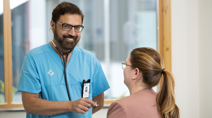 En läkare lyssnar på hjärtat på en patient.