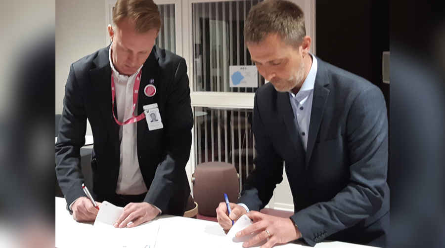 Två män som skriver under avtal.