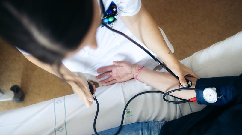 Vårdpersonal tar blodtryck på en patient.