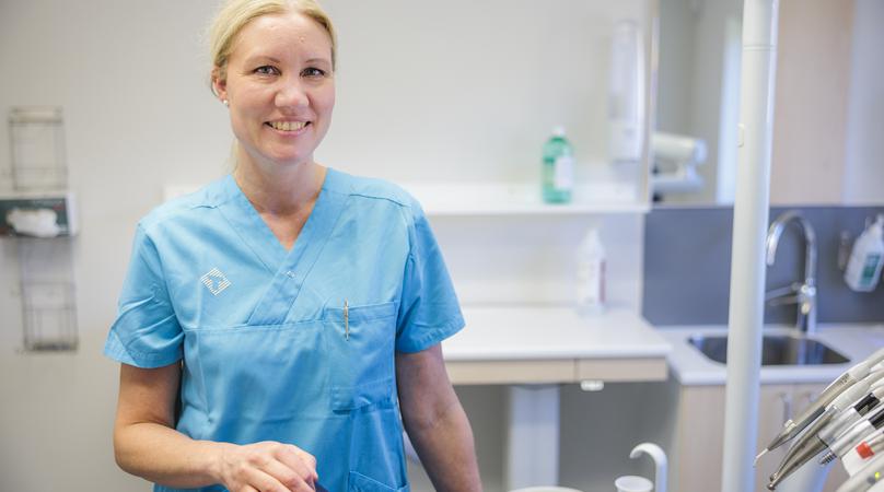 Tandsköterska står håller på stolen