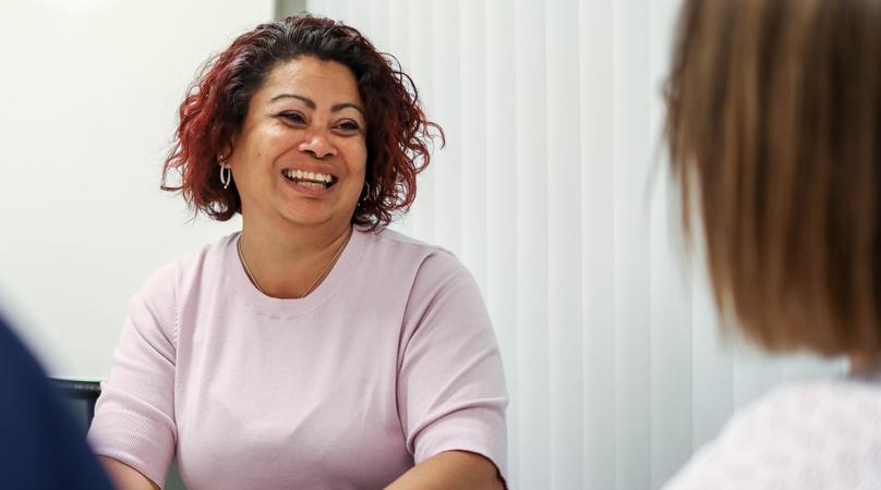 En person ler mot en annan i kontorslandskap.