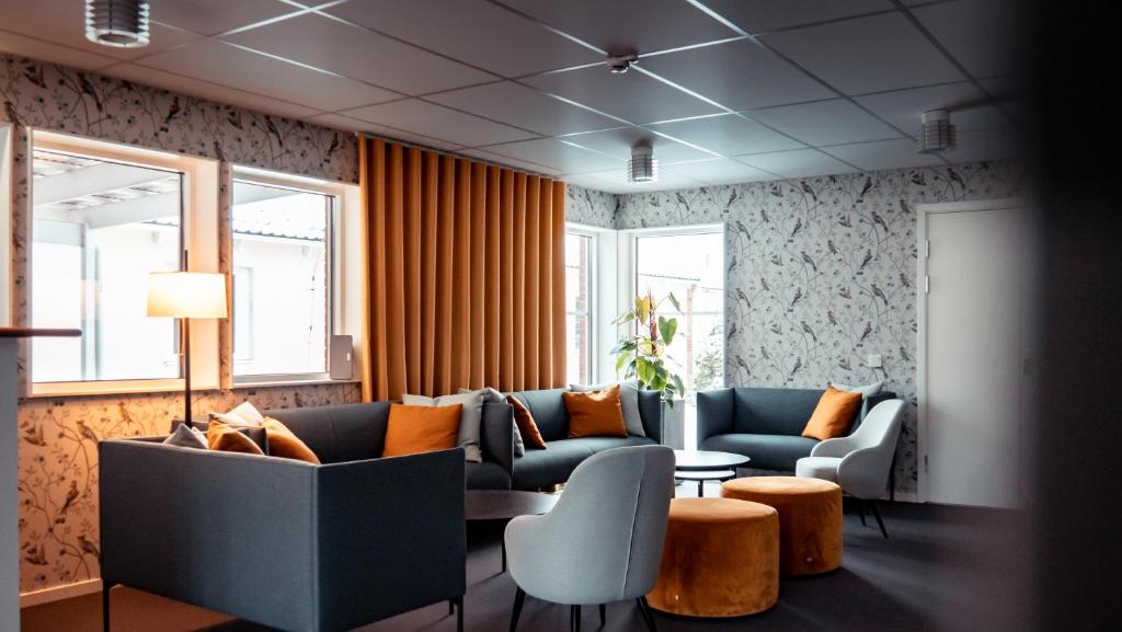 En reception med en soffa, fåtöljer och blommor.