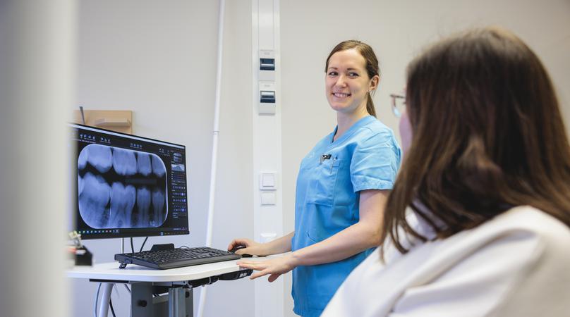 Tandläkare och patient i behandlingsrum.