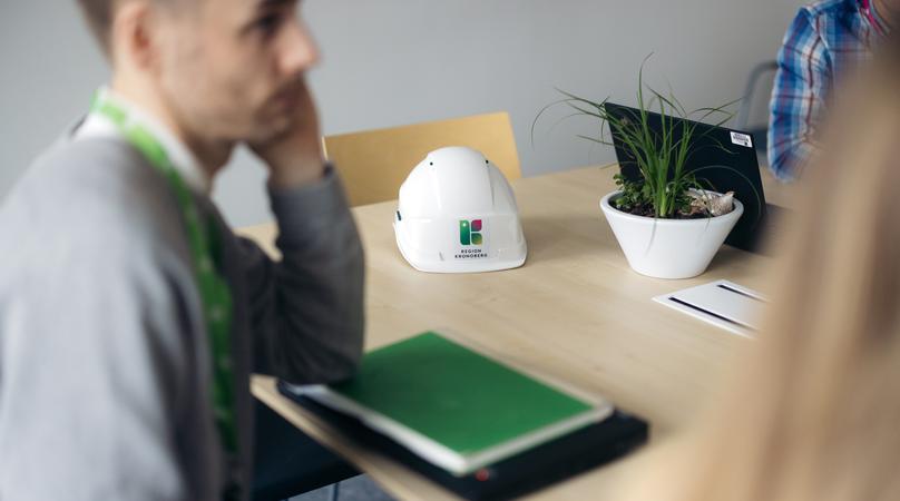 En bygghjälm på ett konferensbord vid ett möte.