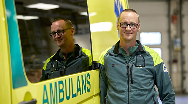 Per som står med axeln lutad mot en ambulans.