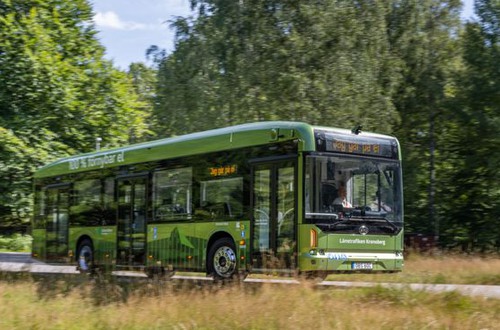 Ljusgrön stadsbuss på landsväg.