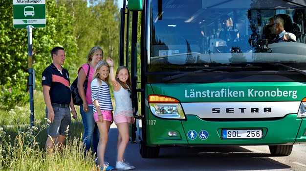 Två vuxna och två barn stiger på en buss.